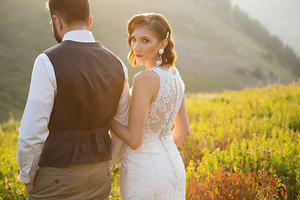 Image of bride and groom in a field with utah mountains